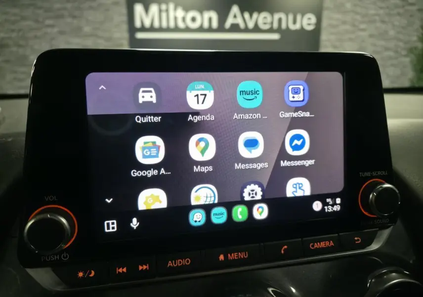 Écran tactile central du Nissan Juke 2024 affichant l'interface multimédia avec commandes physiques éclairées.
