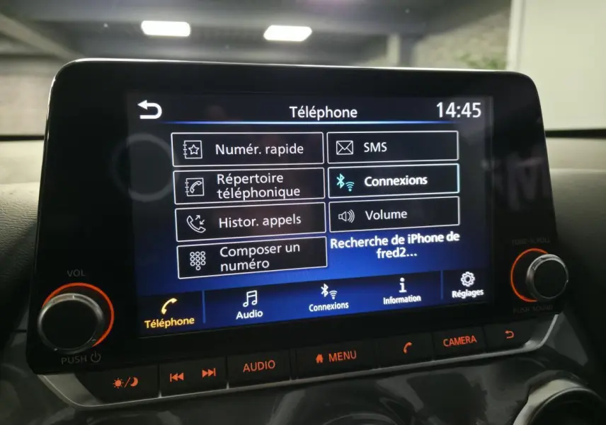 Écran tactile central du Nissan Juke 2024 affichant le menu téléphone avec commandes audio et réglages.