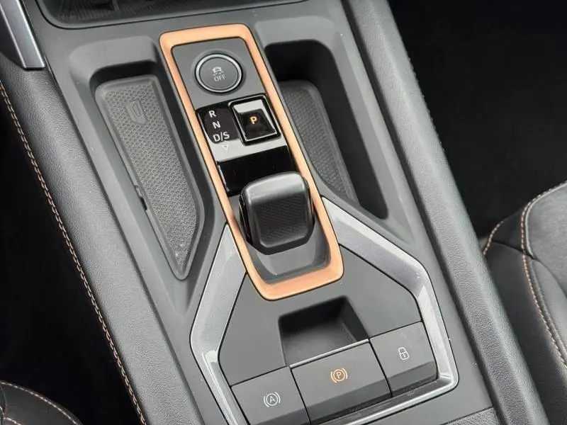 Gros plan sur la console centrale de la CUPRA Formentor 1.5 eTSI Hybrid 2025 avec levier de boîte auto et finitions cuivre.