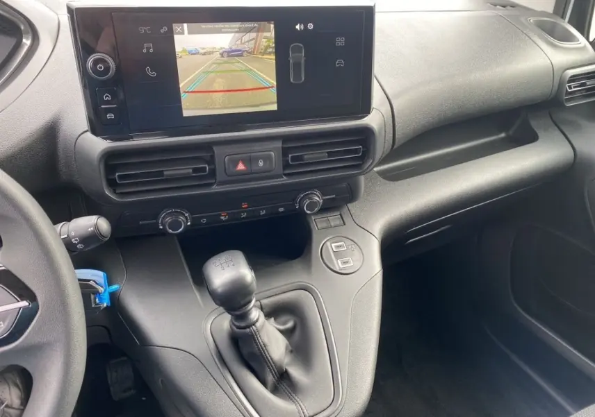 Vue rapprochée de la console centrale du Peugeot Partner 2024, avec écran tactile et levier de vitesses manuel.