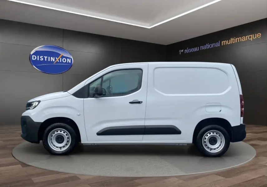 Profil latéral droit du Peugeot Partner blanc 2024 en version utilitaire avec jantes acier et protections noires.