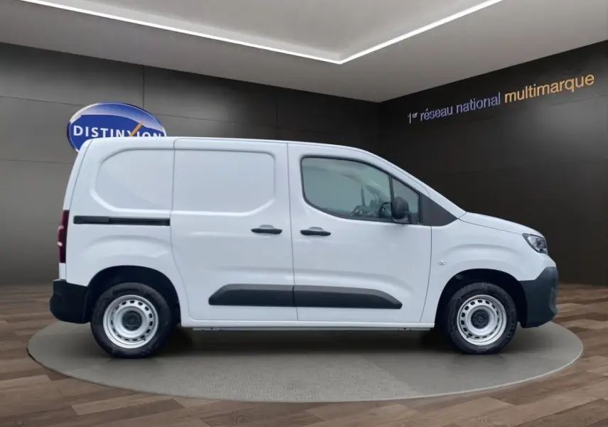Peugeot Partner blanc en vue profil côté gauche, fourgon utilitaire avec protections noires sur les portes.