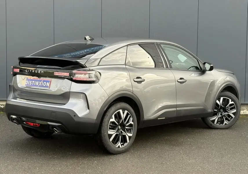 Vue 3/4 arrière droit d'une Citroën C4 Hybrid 145 gris Mercury avec jantes alliage et toit noir brillant.