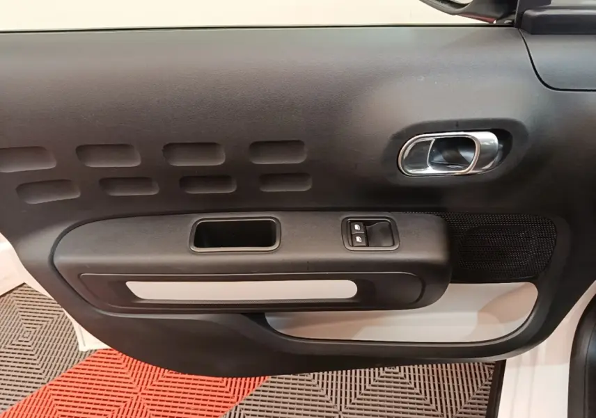 Vue intérieure de la porte avant gauche noire et blanche d'une Citroën C3 PureTech 110 Feel 2019.