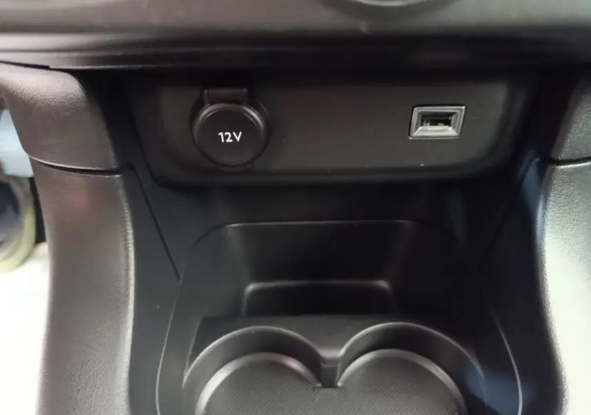 Détail de la console centrale noire de la Citroën C3 avec prise 12V et port USB visible en gros plan.