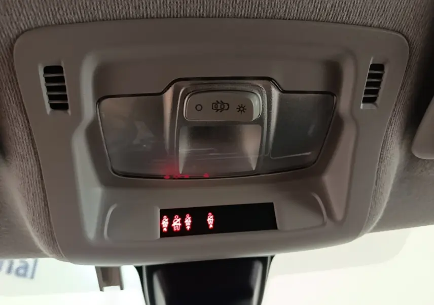 Gros plan sur le plafonnier gris clair de la Citroën C3 blanc, avec éclairage et voyants de ceinture allumés.