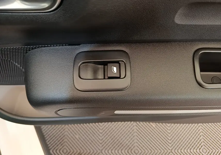 Gros plan sur la commande de lève-vitre côté conducteur de la Citroën C3 blanche de 2019.