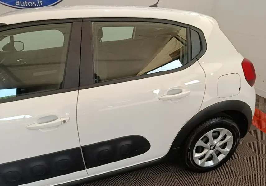 Vue latérale droite d'une Citroën C3 blanche de 2019 avec protections noires sur les portières et jantes argentées.