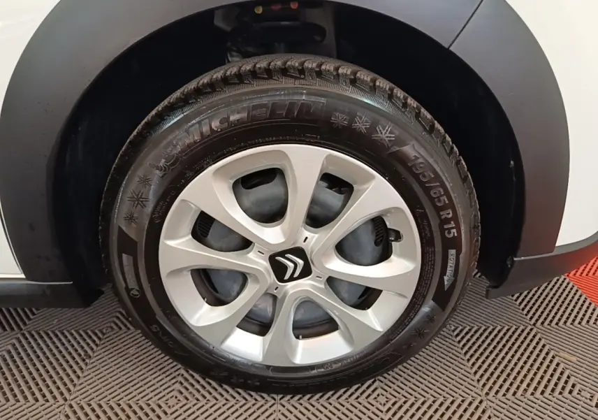 Gros plan sur la roue avant droite d'une Citroën C3 blanche avec jante alliage et pneu Michelin hiver.