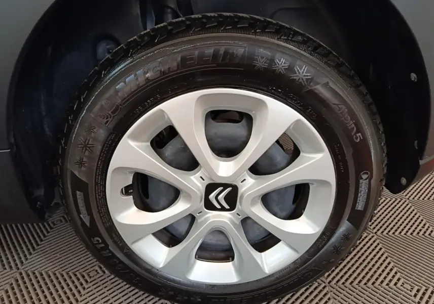Gros plan sur la roue avant droite d'une Citroën C3 blanche, avec jante en alliage et logo Citroën central.
