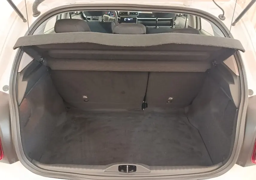 Coffre ouvert vu de l'arrière d'une Citroën C3 blanche, montrant l'espace de chargement et la tablette arrière.