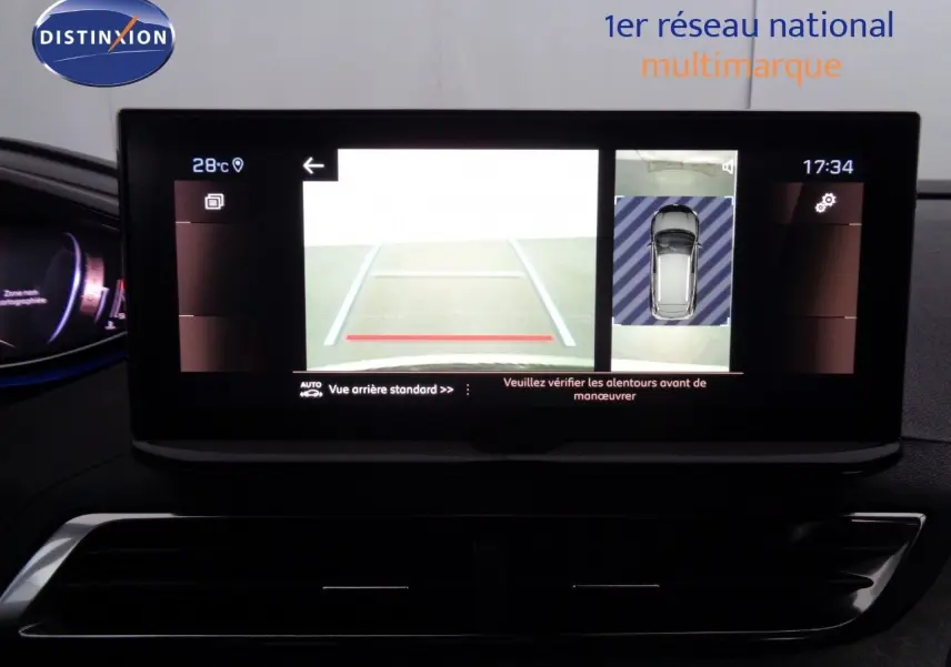 Gros plan sur le volant cuir perforé avec logo Peugeot et tableau de bord numérique du 3008 gris platinium 2023.