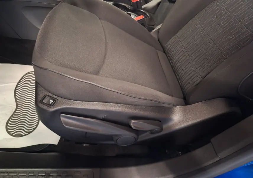 Gros plan sur le siège avant droit noir du FIAT 500X bleu 2024 avec réglage manuel et bouton de chauffage intégré.