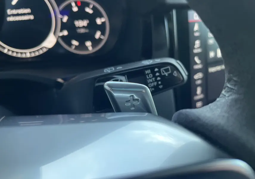 Gros plan sur la palette de changement de vitesse côté droit du volant dans un Porsche Cayenne E-Hybrid gris Kerguelen 2018.