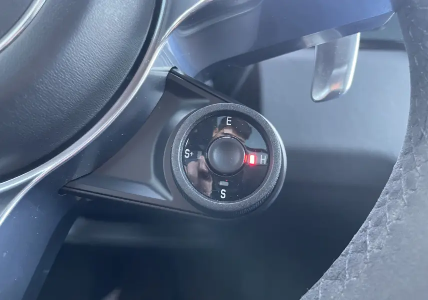 Gros plan sur la molette de sélection de mode de conduite du Porsche Cayenne E-Hybrid 2018, avec éclairage rouge sur mode H.