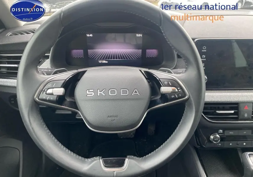 Vue intérieure centrée sur le volant cuir noir SKODA du KAMIQ 2025 avec tableau de bord numérique et écran tactile.