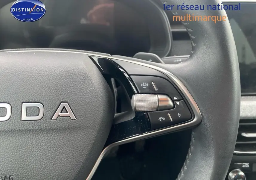 Gros plan sur le volant cuir noir de la Skoda Kamiq 2025, avec commandes multifonctions et molette de réglage.