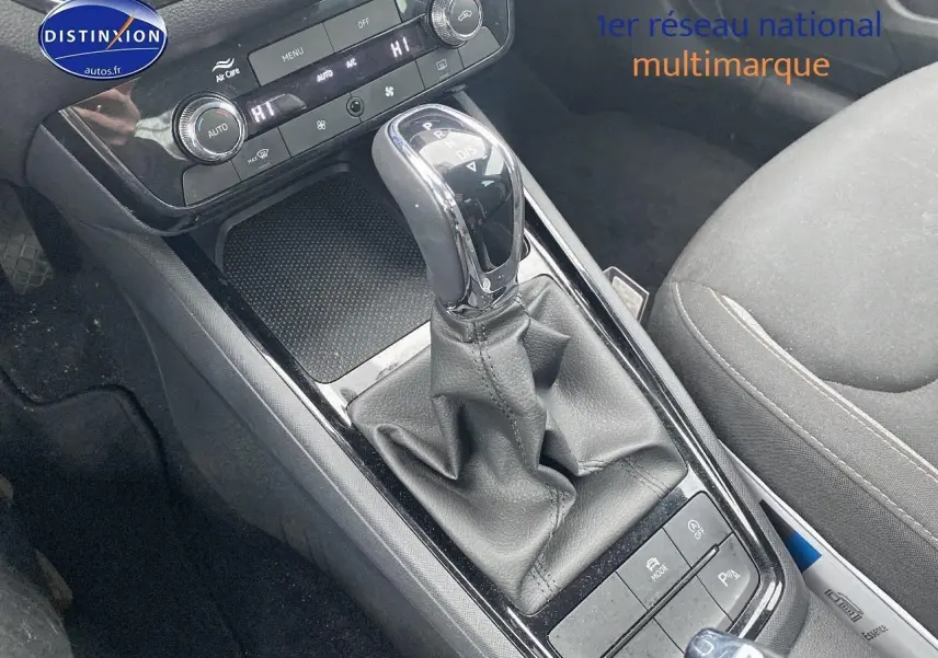 Gros plan sur la console centrale noire du Skoda Kamiq 2025 avec levier de vitesses automatique et commandes de climatisation.