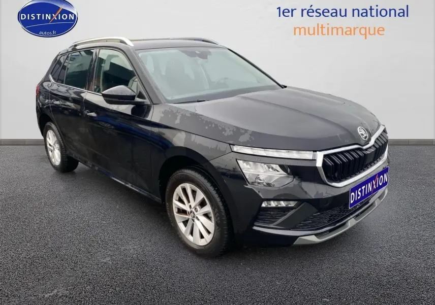 Vue 3/4 avant d'un Skoda Kamiq noir 2025 avec calandre chromée et jantes alu sur sol gris.