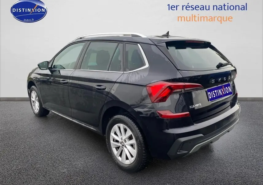 Vue 3/4 arrière droite d'un Skoda Kamiq noir 2025 avec jantes alu et barres de toit argentées.