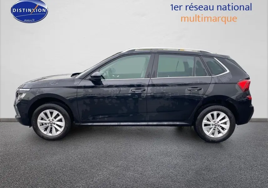 Vue de profil côté gauche d'un Skoda Kamiq noir 2025 avec jantes alu et barres de toit.