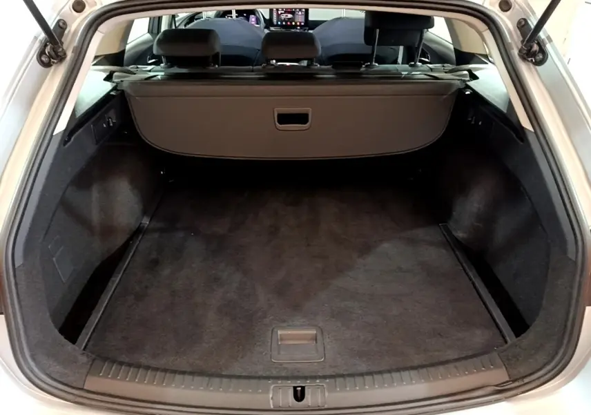 Coffre ouvert vu de l'arrière d'une SEAT Leon gris foncé, montrant l'espace de chargement et la tablette cache-bagages.