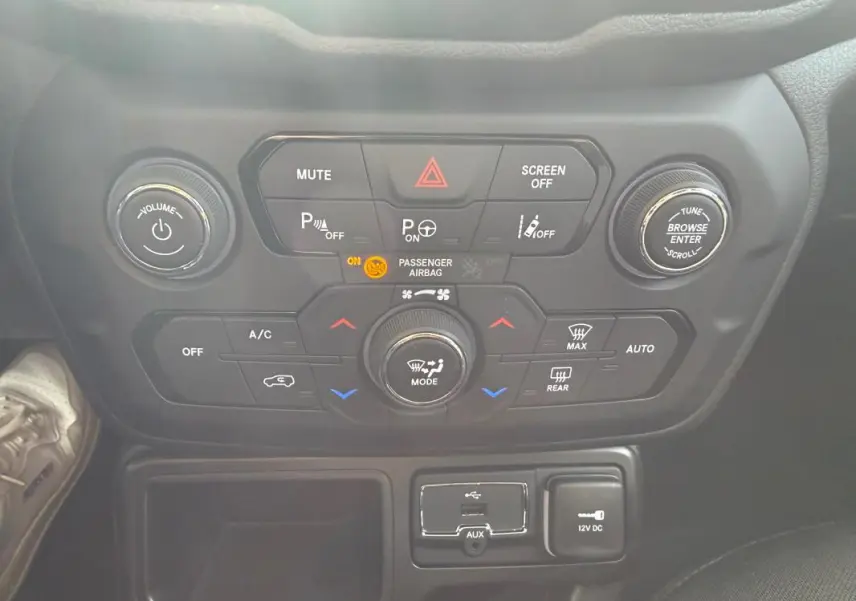 Vue rapprochée du tableau de bord central de la Jeep Renegade 2023, montrant les commandes de climatisation et multimédia.