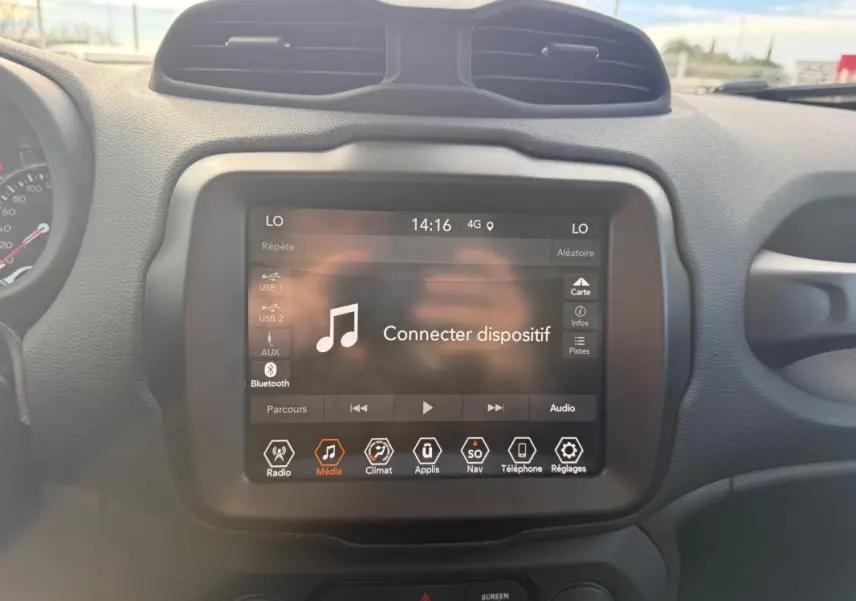 Vue rapprochée de l’écran tactile multimédia du Jeep Renegade bleu 2023 avec interface connectivité Bluetooth affichée.