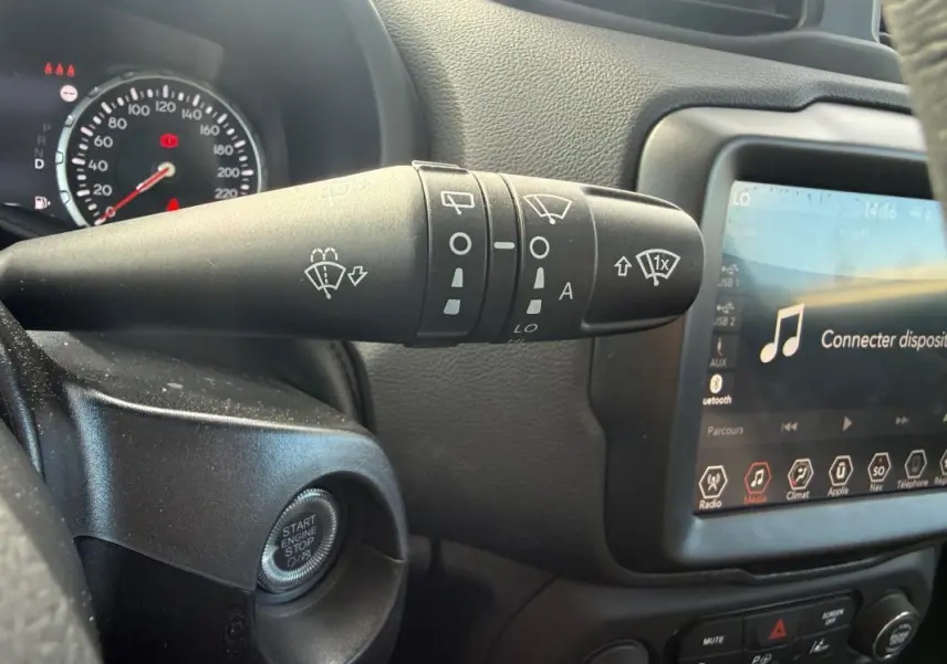 Gros plan sur la commande d’essuie-glace et l’écran tactile du tableau de bord intérieur de la Jeep Renegade 2023.