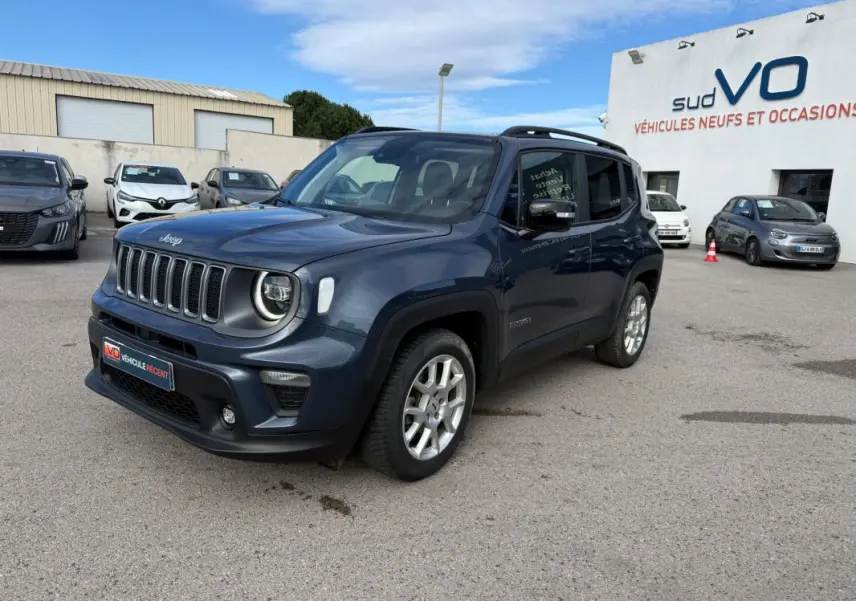 Jeep Renegade bleu en 3/4 avant droit, avec barres de toit et jantes alliage visibles, stationné en extérieur.