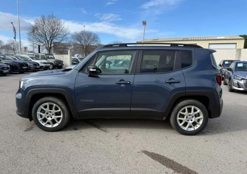 Vue de profil côté gauche d'un Jeep Renegade bleu 2023 avec barres de toit et jantes alliage 17 pouces.