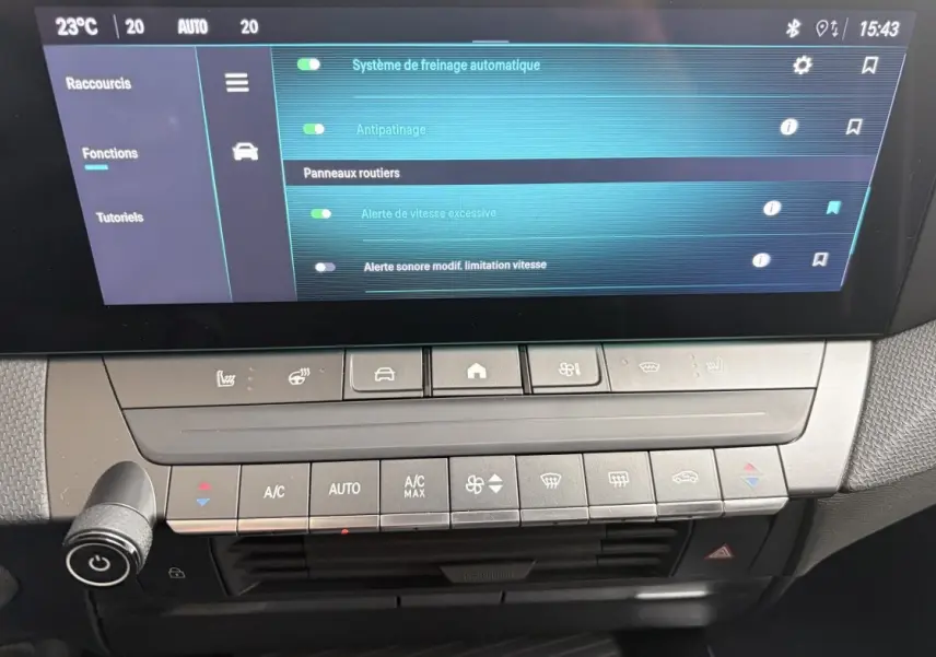 Vue rapprochée de la console centrale et écran tactile de l’Opel Astra blanc, affichant les réglages d’aide à la conduite.