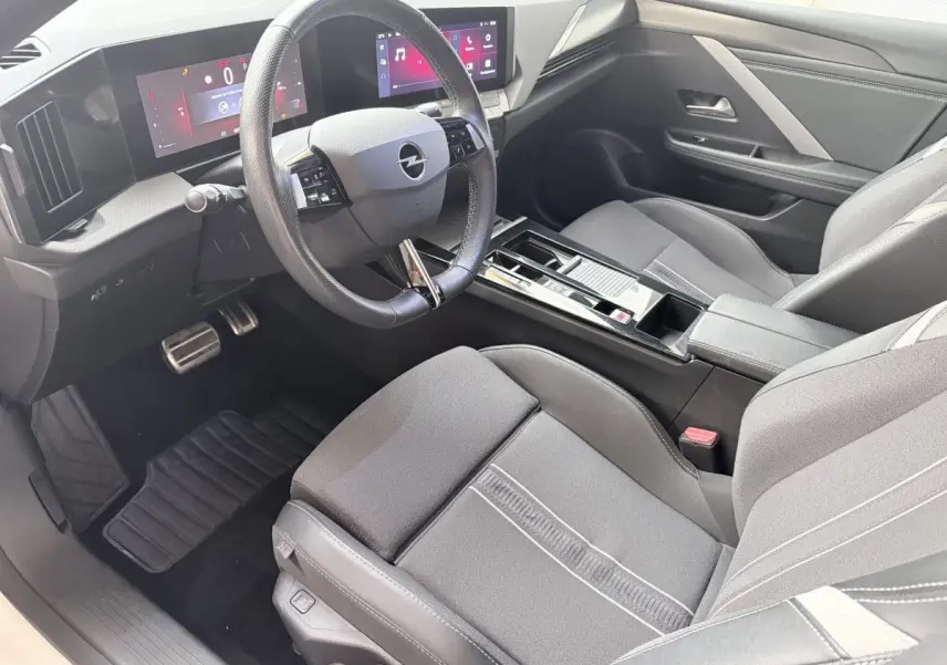 Vue intérieure côté conducteur de l'Opel Astra 2024, volant cuir multifonctions et tableau de bord digital.
