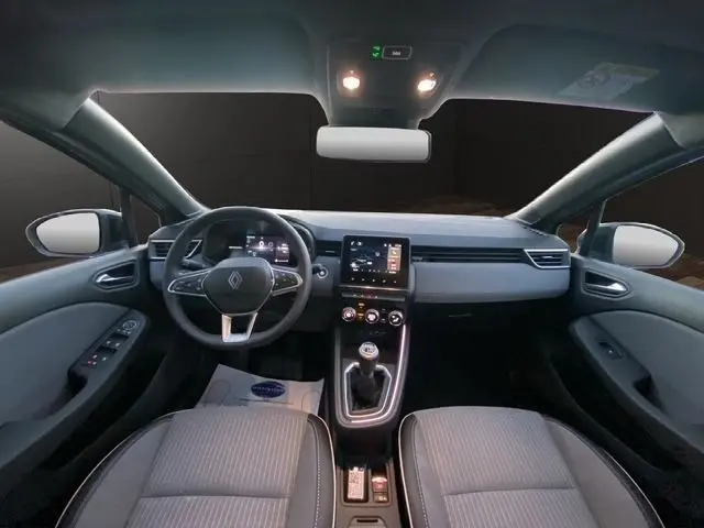 Vue intérieure avant de la Renault Clio Techno TCe 90 2025, tableau de bord moderne avec écran tactile central et volant multifonctions.