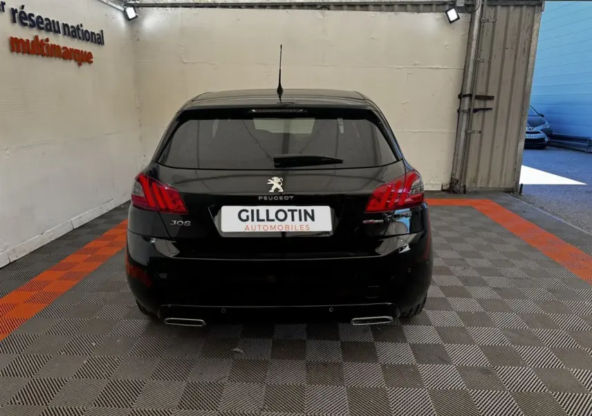Vue arrière d'une Peugeot 308 noire GT Line 2018, avec feux rouges et double sortie d'échappement chromée visible.
