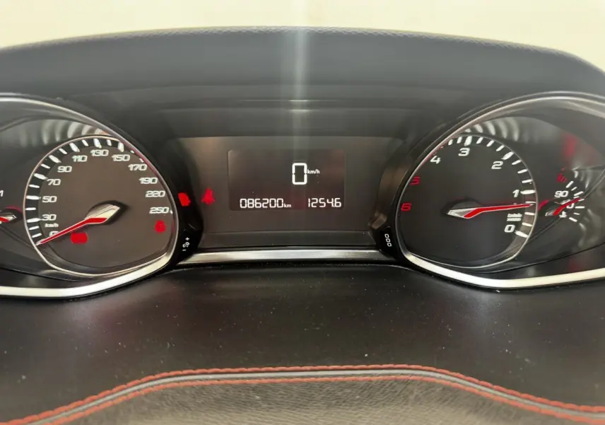 Vue rapprochée du tableau de bord de la Peugeot 308 noir, affichant le compteur et l'odomètre à 86 200 km.