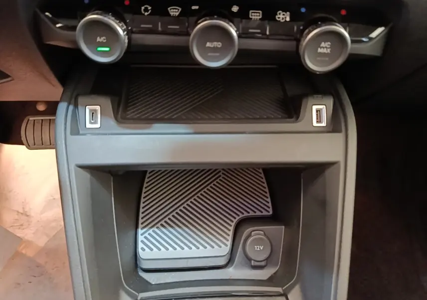Gros plan sur la console centrale du Citroën C4 X 2023, montrant les commandes de climatisation et prises USB et 12V.