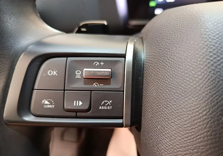 Gros plan sur les commandes multifonctions du volant cuir noir d'une Citroën C4 X PureTech 130 Shine 2023.