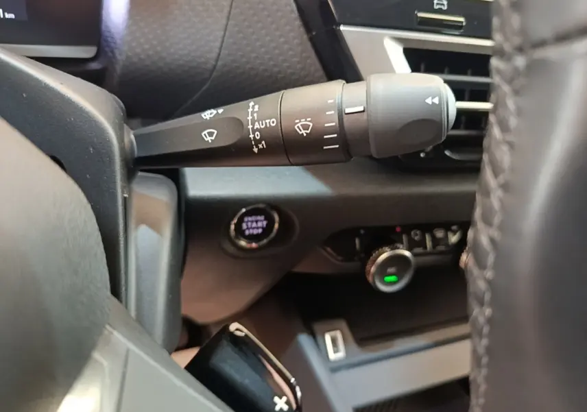 Gros plan sur la commande d’essuie-glace et le bouton démarrage du tableau de bord intérieur noir du Citroën C4 X.
