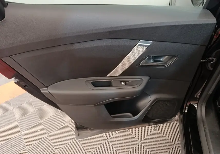 Vue intérieure de la porte avant gauche noire du Citroën C4 X 2023 avec insert décoratif gris et commande de vitre.