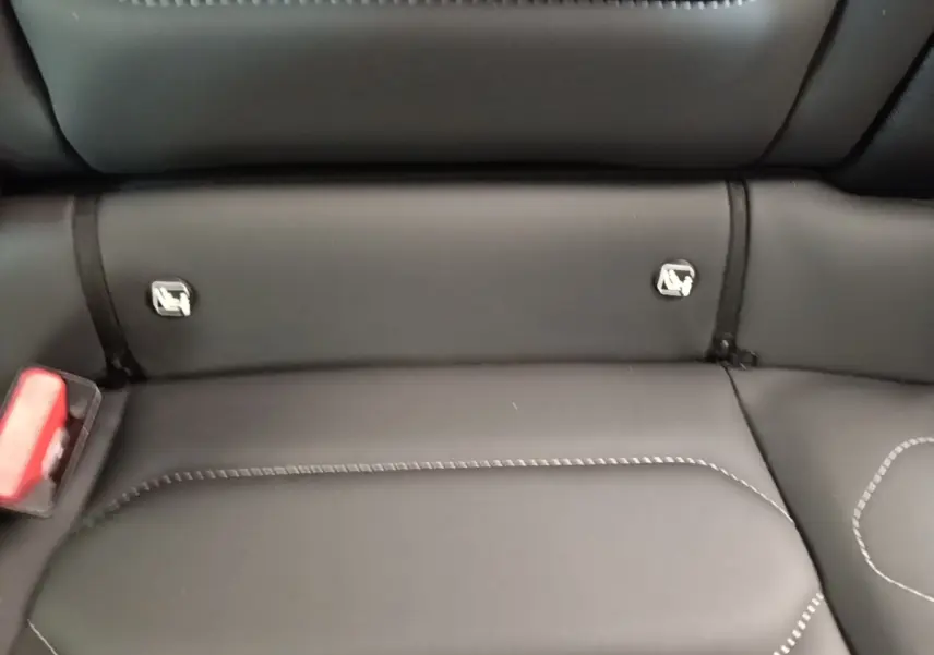 Gros plan sur la banquette arrière noire du Citroën C4 X 2023 avec fixation Isofix et surpiqûres contrastées.