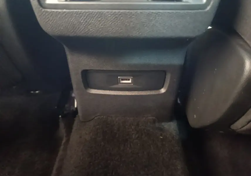 Prise USB noire vue en gros plan sur la console arrière du Citroën C4 X PureTech 130 Shine 2023.