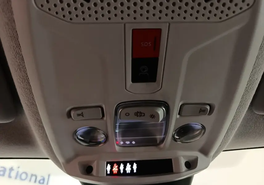 Vue intérieure du plafonnier gris clair avec boutons SOS et éclairage dans une Citroën C4 X noire de 2023.