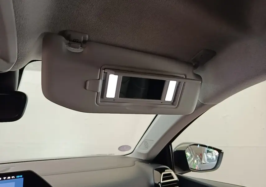 Détail intérieur du pare-soleil avec miroir éclairé côté conducteur de la Citroën C4 X noire, vue avant droite.