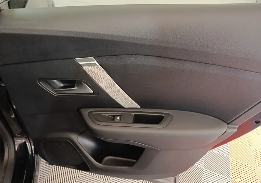Vue intérieure de la porte côté gauche noire du Citroën C4 X 2023 avec insert décoratif gris et poignée intégrée.