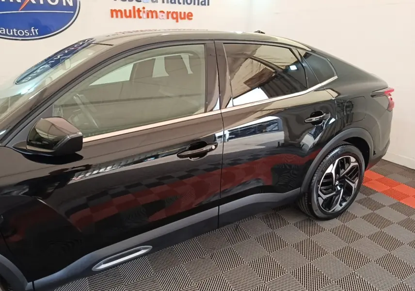 Profil droit d'une Citroën C4 X noire 2023 avec jantes alliage et lignes de toit fluides.