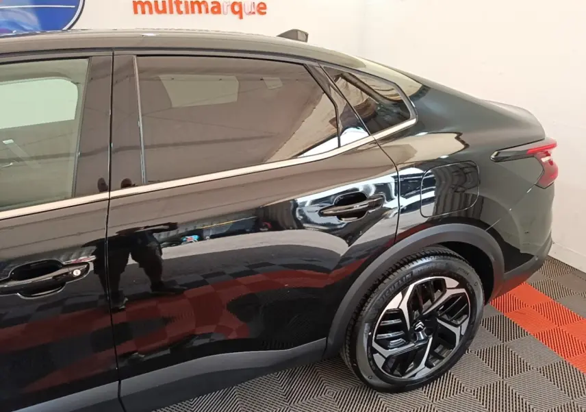 Vue côté droit arrière de la Citroën C4 X noire 2023, soulignant la ligne fluide et les jantes modernes.