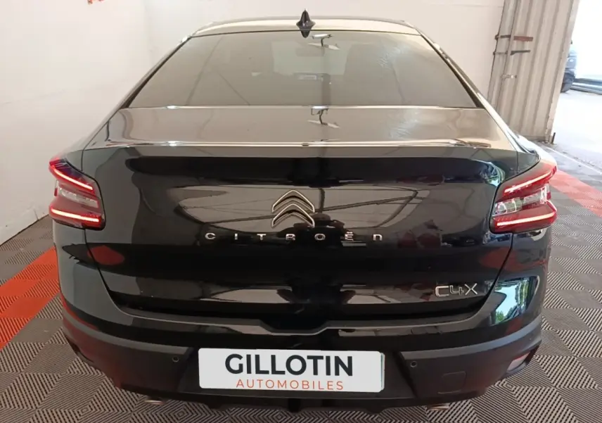 Vue arrière d'une Citroën C4 X noire 2023 avec feux LED allumés et logo distinctif sur coffre.