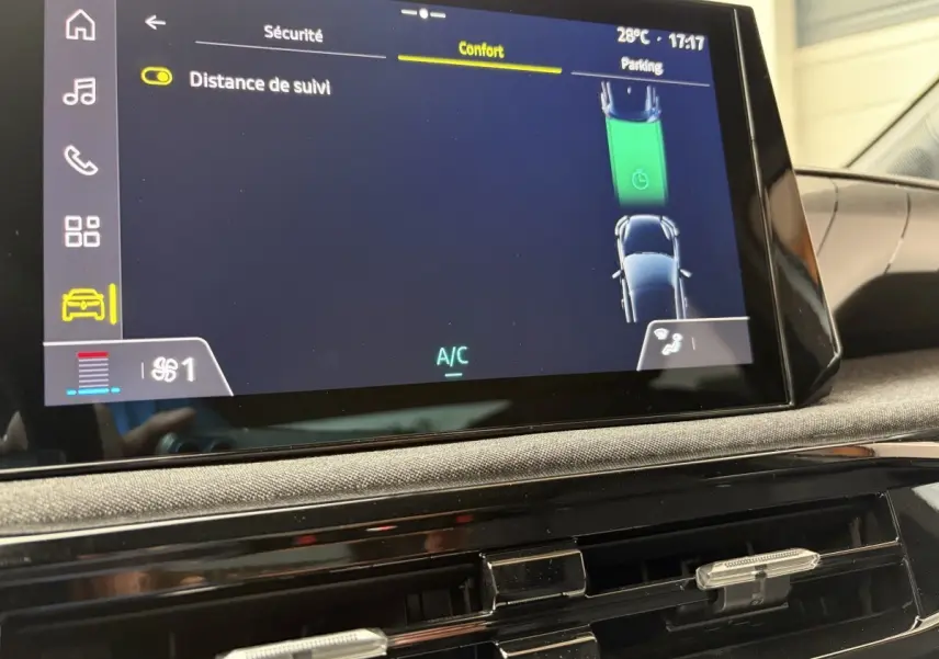 Vue rapprochée de l'écran tactile central de la Renault Clio blanche 2026, affichant les réglages de confort et sécurité.