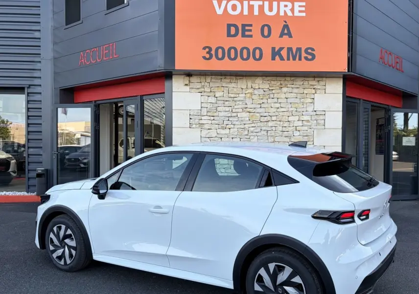 Renault Clio Evolution TCe 115 blanc vue côté gauche en 3/4 arrière, avec feux arrière LED et toit noir contrasté.
